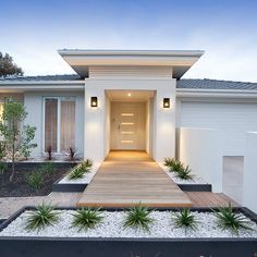 modern house with front entrance and landscaping at dusk