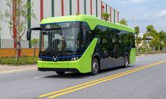 a green bus is driving down the street