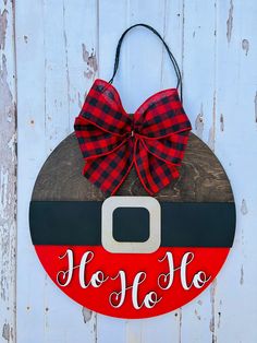 a wooden sign that says ho ho ho on it with a bow hanging from the front