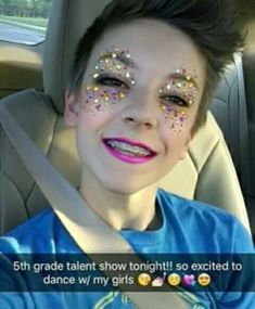 a young boy sitting in the back seat of a car with his face painted gold and silver