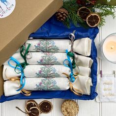 a box filled with napkins next to a candle and some other items on a table