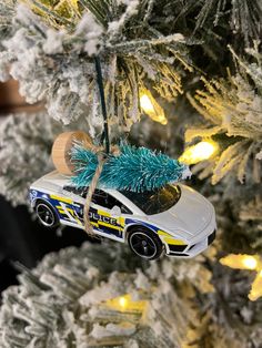 a police car ornament hanging from a christmas tree