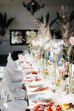 a long table with plates and flowers on it