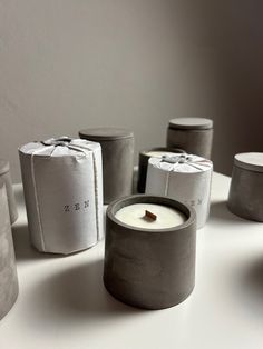 several candles sitting on top of a white table next to bags with writing on them