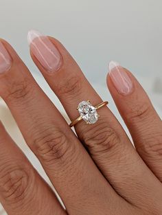 a woman's hand with a ring on it and a diamond in the middle