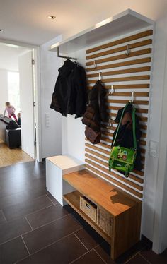 there is a coat rack on the wall with coats hanging from it's hooks