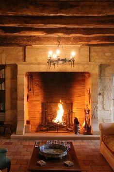 a living room filled with furniture and a fire place in the middle of a fireplace