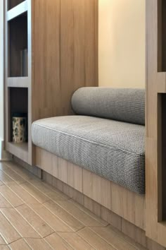 a couch sitting on top of a wooden floor next to a book shelf