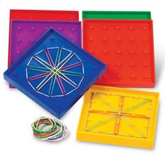 four different colored boxes with various items in them on a white surface, one is holding a string and the other has a piece of paper attached to it