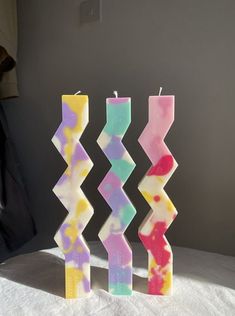 three colorful candles sitting on top of a table