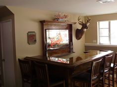 a dining room table with chairs and a deer head mounted on the wall