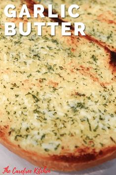 a close up of a pizza on a plate with the words garlic butter over it