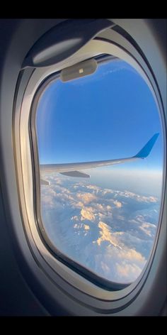 an airplane window looking out at the clouds