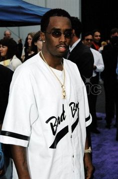 a man wearing sunglasses and a white shirt is standing in front of a group of people