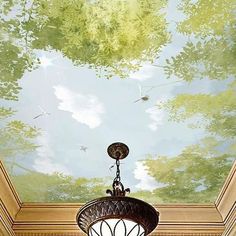 a chandelier hanging from the ceiling in front of a painting on the wall