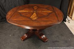 a wooden table with an intricate design on it's top and four leaves at the base