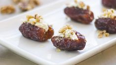 figs filled with nuts and cheese on a white plate, ready to be eaten