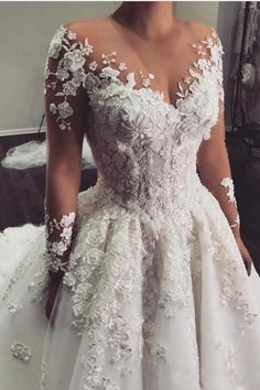 a woman in a white wedding dress standing next to a mirror