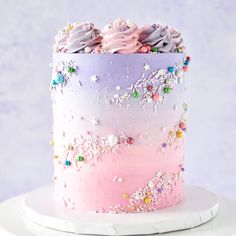 there is a pink and purple cake with sprinkles on the top it