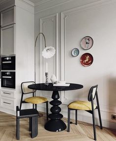 a black table with yellow chairs in a white room