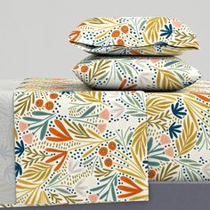 three sheets are stacked on top of each other in front of a gray background with orange, blue and green leaves