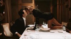 a man kissing a woman on the cheek at a dinner table