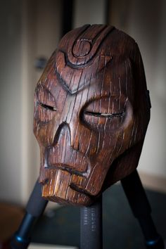 a wooden mask sitting on top of a table