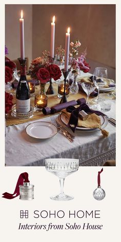 a table set with wine glasses, plates and candles