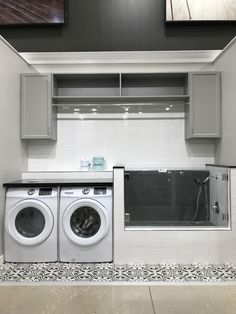 a washer and dryer are in the middle of a room with tile flooring