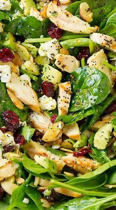 a salad with chicken, spinach and cranberries is shown on a plate