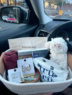 a person holding a basket filled with items in the back seat of a car,