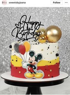 a mickey mouse birthday cake with balloons on top