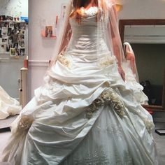 a woman in a wedding dress is posing for the camera