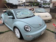 a blue convertible car parked next to other cars