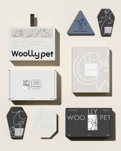 various logos and business cards are arranged on a white surface, including the logo for woolly pet