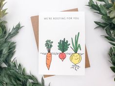 a card with carrots and radishes on it next to green leaves, which says we're rooting for you