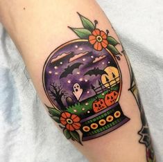 a person with a tattoo on their arm that has an image of a snow globe in it