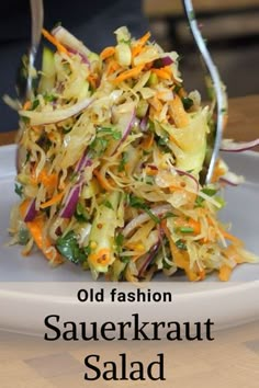 a white plate topped with coleslaw slaw and carrots next to a fork