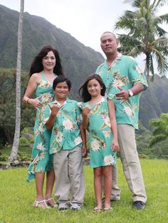 a family poses for a photo in front of the mountains and palm trees, while wearing matching outfits