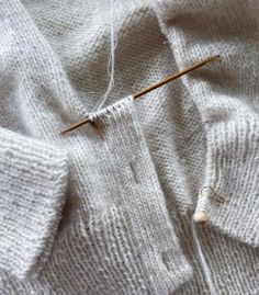 the knitting needles are being used to knit sweaters