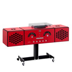 a red record player sitting on top of a black stand