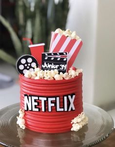 a red bucket filled with popcorn sitting on top of a table