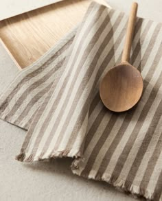 a wooden spoon sitting on top of a striped napkin