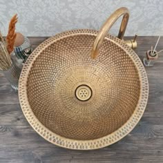 an antique style sink is shown on a wooden table with vases and dried flowers