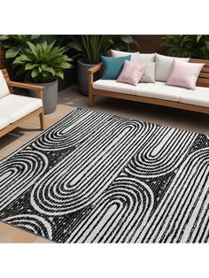 a black and white area rug sitting on top of a wooden floor next to two couches