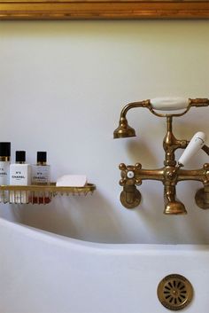 a bathroom sink with two faucets and soap dispensers on the wall