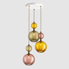 three different colored glass balls hanging from a ceiling