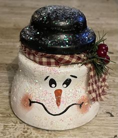 a snowman jar sitting on top of a wooden table