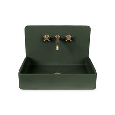 a green sink with two brass faucets on the front and side, against a white background