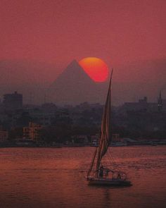 a sailboat in the water at sunset